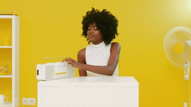 Afrikaanse vrouw gaat naar muziek luisteren in geel kantoor — Stockvideo