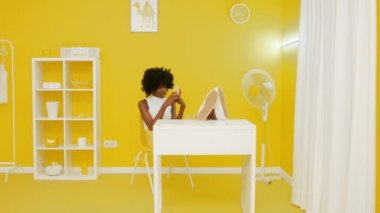 Siyah Kadın Akıllı Telefon Kullanarak Ofiste Rahatlıyor