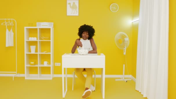 Kobieta je pianki w żółtym pokoju — Wideo stockowe