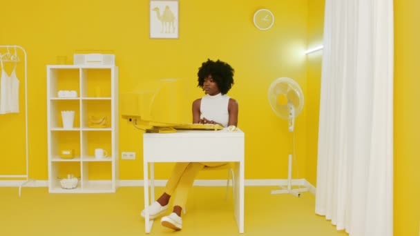 Молодая африканская женщина работает за старым жёлтым компьютером — стоковое видео