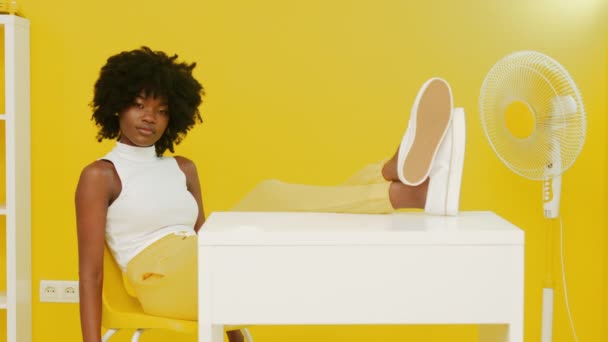 노란색 실내에 앉아 있는 아프리카 여인의 모습 — 비디오