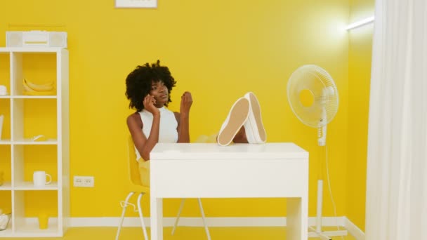 Zwarte vrouw praat telefoon in geel kantoor — Stockvideo