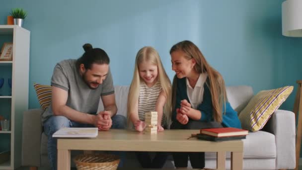 Piccola ragazza gioca Jenga con mamma e papà — Video Stock