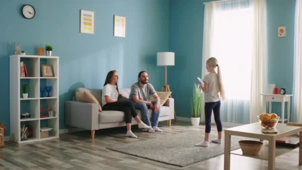 Liten flicka leker spel i vardagsrummet med föräldrar — Stockvideo