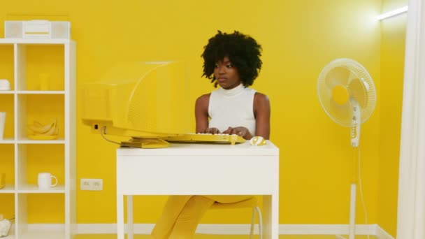 Černá žena pracuje na staré žluté PC — Stock video