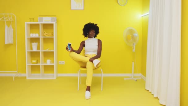 Африканська жінка сидить на офісному стільці і розважається — стокове відео