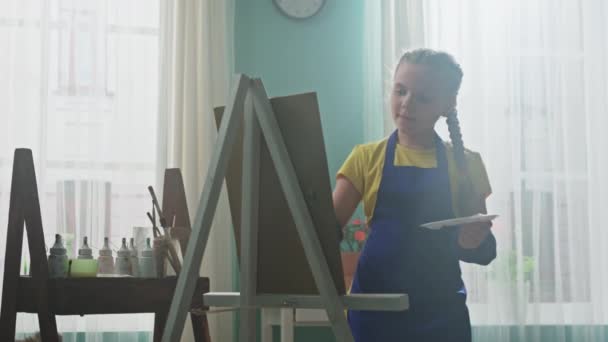 Niña pequeña se centra en la pintura — Vídeo de stock