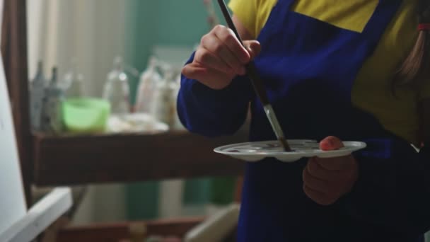 Niño en delantal azul está pintando — Vídeo de stock