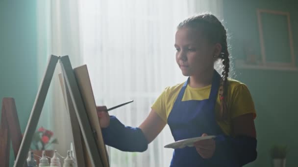 Chica estudiante está practicando pintura — Vídeo de stock