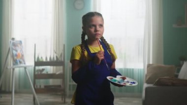 Küçük kız ressam bazı fikirleri yansıtıyor.