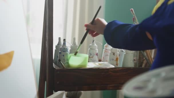 Kind is het schoonmaken borstel en zetten in verven — Stockvideo