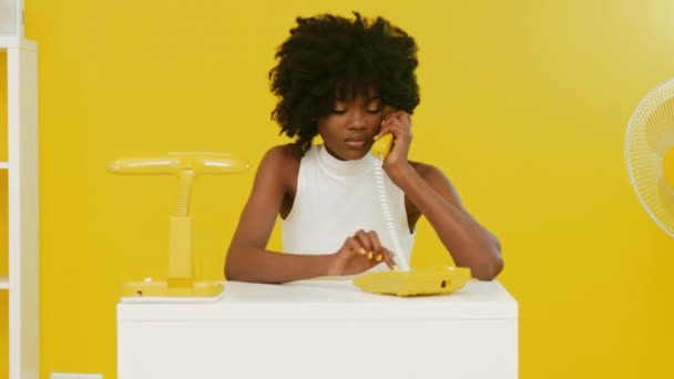 Черная женщина разговаривает по телефону в офисе — стоковое видео