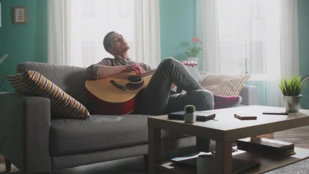 젊은 남자가 멜로디를 기타로 연주하고 있다 — 비디오