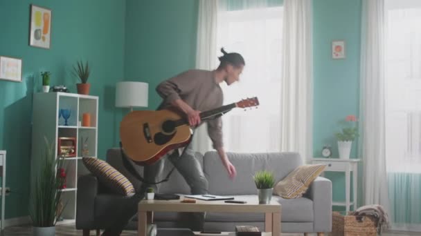 L'homme entre dans le salon pour se détendre sur le canapé — Video