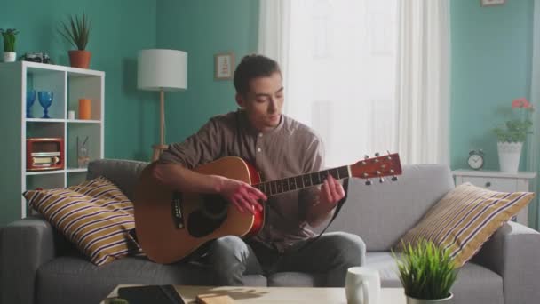 Jovem está tocando guitarra — Vídeo de Stock
