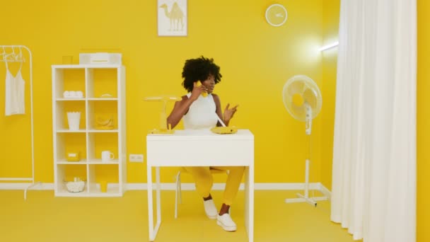 Bazige vrouw praat telefoon in geel creatief kantoor — Stockvideo