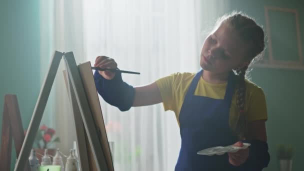 Belle fille en tablier bleu est la peinture — Video