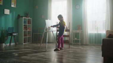 Küçük kız tuvale resim yapıyor.