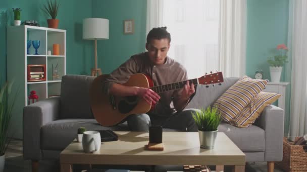 Hombre está grabando vídeo de tocar la guitarra — Vídeo de stock