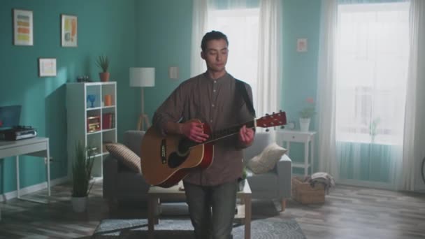 Giovane uomo sta suonando la chitarra a casa — Video Stock