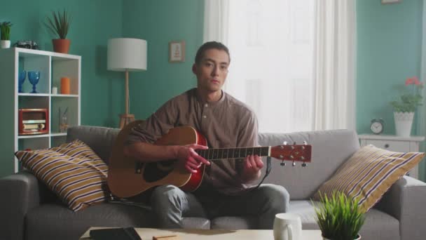 Porträtt av ung man som håller gitarr — Stockvideo