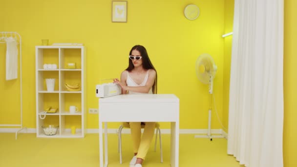 Mujer joven está escuchando música en la oficina amarilla — Vídeos de Stock