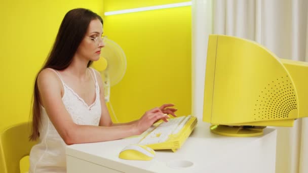 Žena v bílém top pracuje na žlutém PC — Stock video