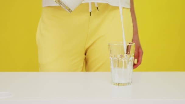 Milch wird von Frau ins Glas geschüttet — Stockvideo
