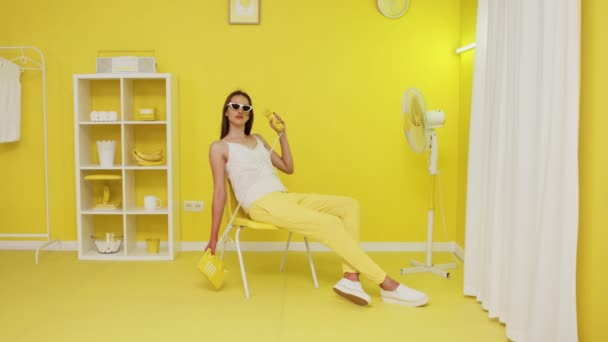 Jeune femme est assis dans la chaise de bureau et tenant le téléphone rétro — Video