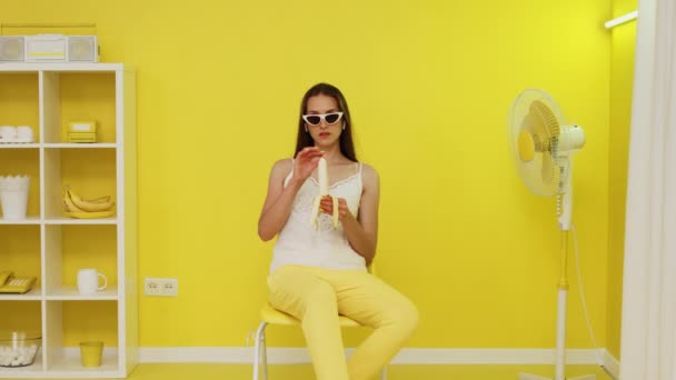 Νεαρή γυναίκα μοντέλο ξεφλουδίζει μπανάνα — Αρχείο Βίντεο