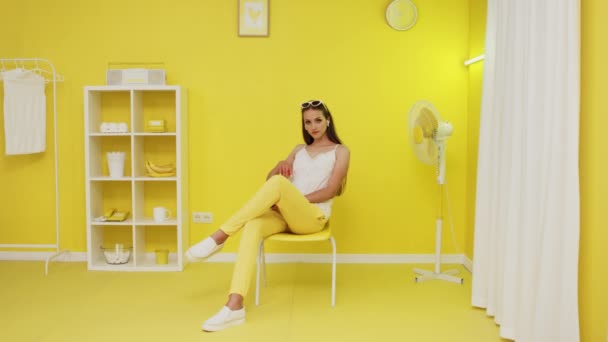 Retrato da bela mulher sentada no interior amarelo — Vídeo de Stock