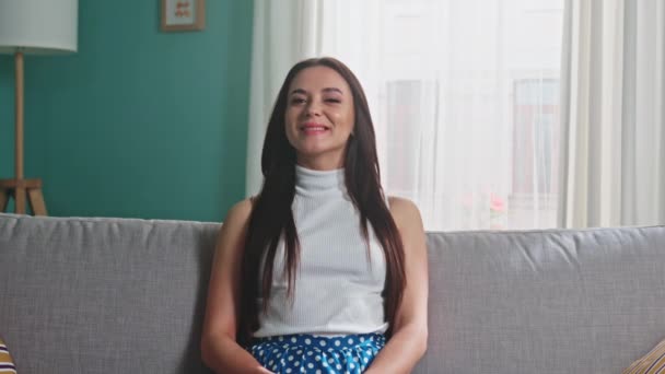 Wanita yang senang duduk di atas Sofa dan tersenyum — Stok Video