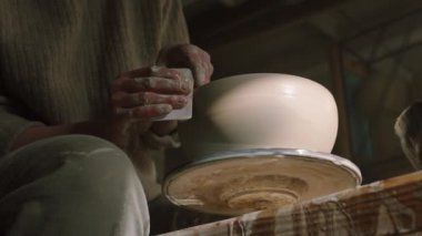 Potter çömlek çarkında çiğ çamur yapıyor.
