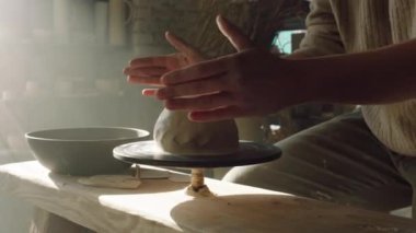 Potter, çömlek çarkında Clay 'i şekillendiriyor.