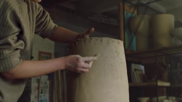 Vrouw pottenbakker is schrapen vaas van ruwe klei — Stockvideo