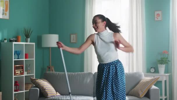 Женщина чистит пол и танцует — стоковое видео