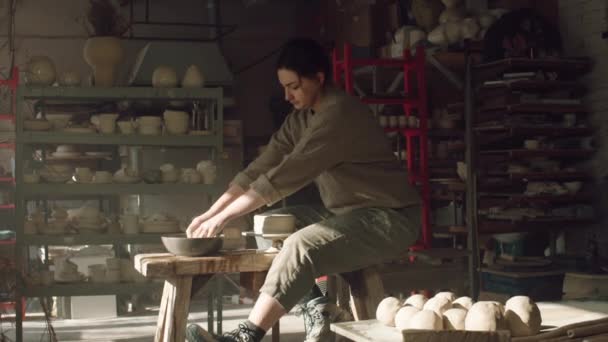 Kobieta Potter tworzy naczynie z mokrej gliny na obracającym się dysku — Wideo stockowe