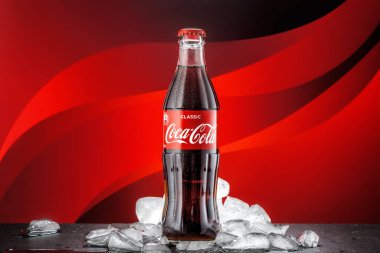 MOSCOW, RUSSIA - 5 Mayıs 2020: Buzlu parlak renkli arka planda klasik Coca-Cola şişesi.