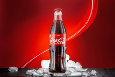 MOSCOW, RUSSIA - 5 Mayıs 2020: Buzlu parlak renkli arka planda klasik Coca-Cola şişesi.
