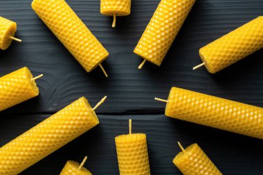 Balmumundan yapılmış dekoratif mumlar. İç mekan için bal aromalı. Koyu ahşap arka planda gelenek..