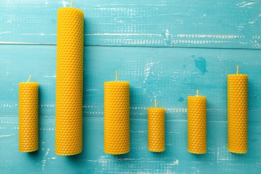 İç mekan için bal aromalı balmumundan yapılmış dekoratif mumlar ve mavi ahşap arka planda gelenek..