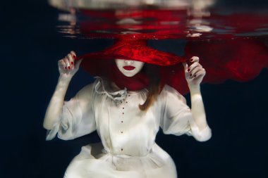 Su altında kırmızı şapkalı kız