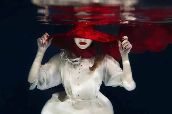 Su altında kırmızı şapkalı kız