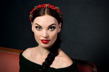 gülümseyen genç güzel esmer kırmızı çelenk ve örgü ile portresi