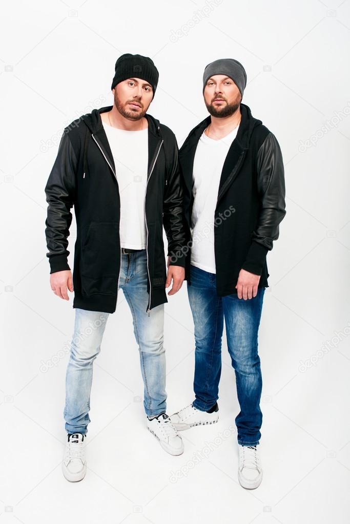 Portrait of two men in black jackets and hats