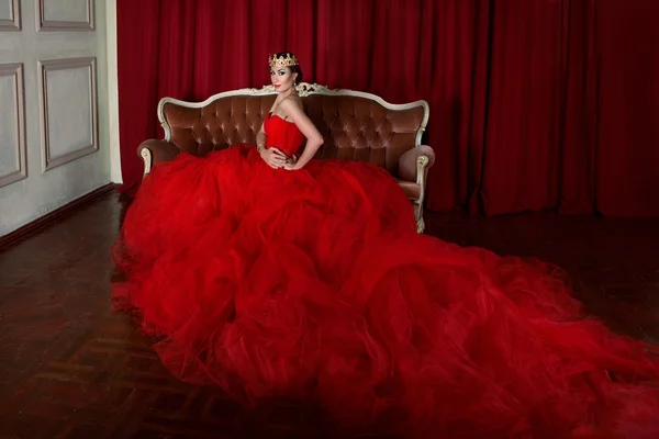 Bella ragazza in abito rosso lungo e in corona reale — Foto Stock