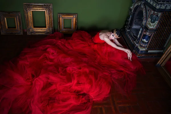 Schönes Mädchen im langen roten Kleid und in königlicher Krone — Stockfoto