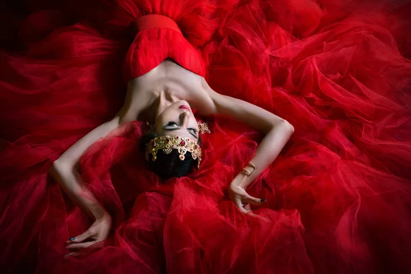 Krásná dívka v dlouhé červené šaty a v královské koruny — Stock fotografie