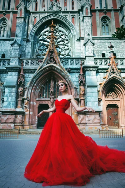 Красива дівчина в довгій червоній сукні і в королівській — стокове фото