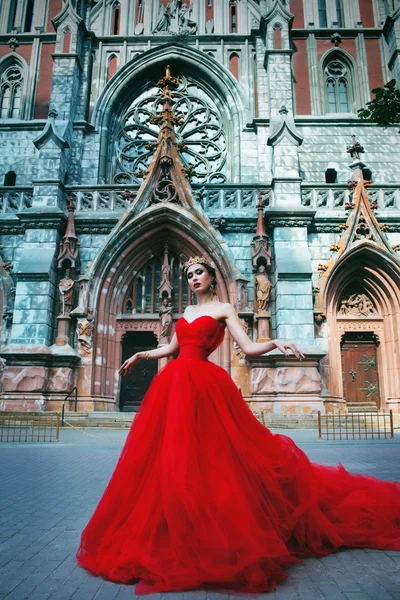 Menina bonita em vestido vermelho longo e em real — Fotografia de Stock